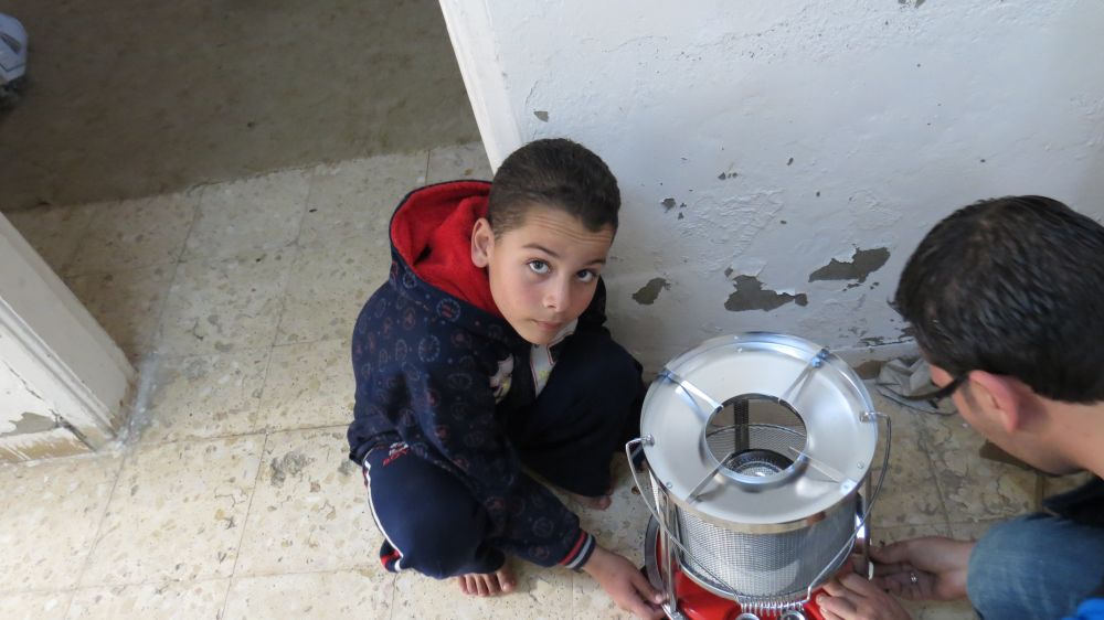 Zarfeh's son puts together a heater supplied by Caritas.