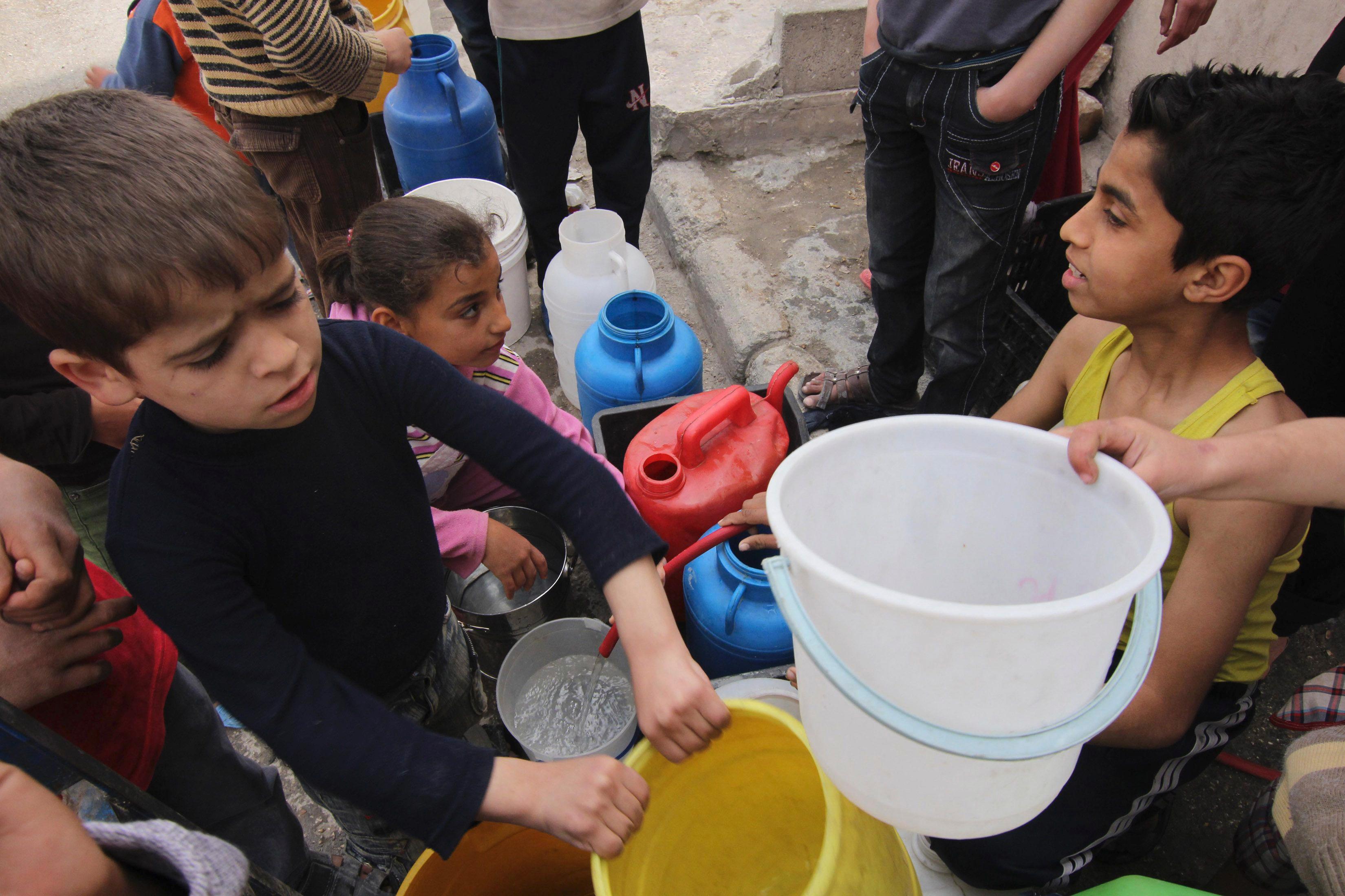 Children wait to collect water in Aleppo April 2, 2013. Around Syria, water shortages are worsening and supplies are sometimes contaminated, putting children at increased risk of diseases. REUTERS/Giath Taha 